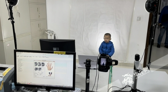 小霖在拍摄身份证照片.华龙网-新重庆客户端记者 余志斌 摄