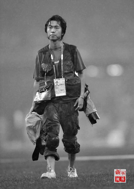  2008年9月9日，新华社湖南分社记者李尕在大雨中的鸟巢采访北京残奥会。