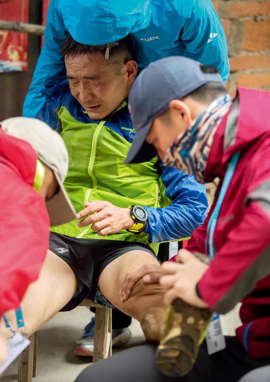 2017年10月14日，在浙江丽水市松阳县举行的2017中国·松阳国际天空跑挑战赛中，工作人员在为一名抽筋的选手提供医疗服务。图/新华