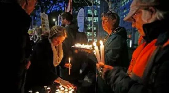 缓慢的死亡:史上最残忍的“死亡卡车” 如何走上不归路? 部分英国民众在英国内政部外自发为39名逝者举办追思会。