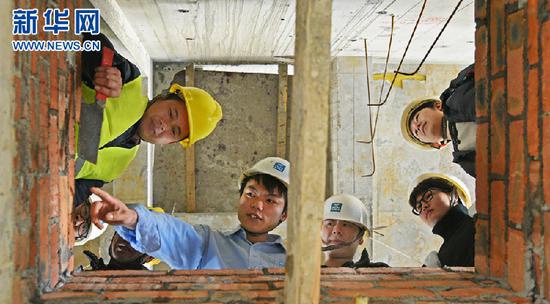  邹彬分享砌墙技艺，给工友们打样板做示范。（中建五局供图）