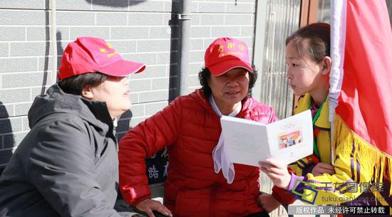 学雷锋活动日:学雷锋纪念日 北京在行动 电厂路小学《小小冬奥组委》“学雷锋”志愿服务冬奥宣讲团向居民赠送学校印的《冬奥有我 知识读本》。学校供图。