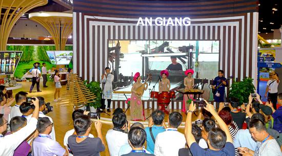 9月21日，在东博会“魅力之城”展厅越南安江省的展台前，来自越南的艺术家们用特有的乐器为专业观众演奏脍炙人口的歌曲。    广西日报-广西云客户端记者 李军/摄