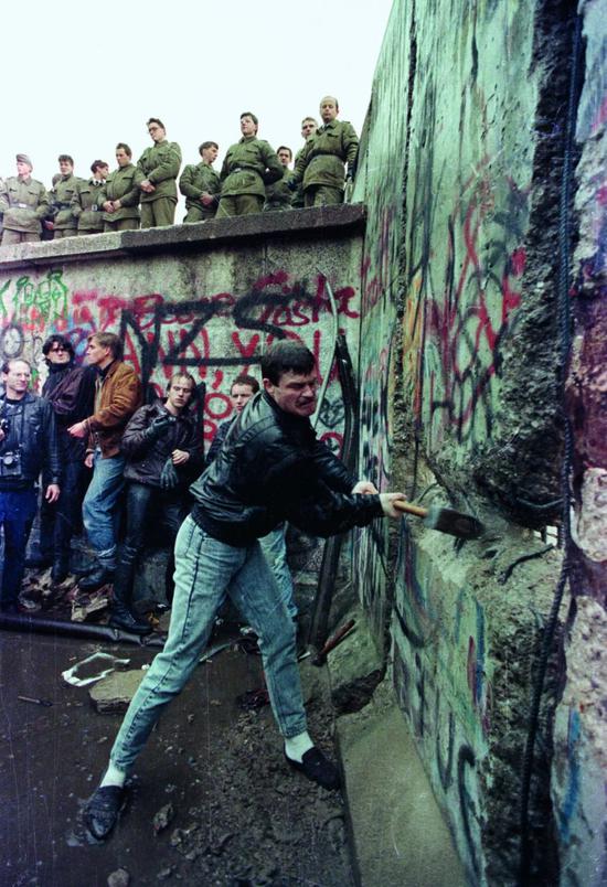  1989年11月11日，民众参与拆除柏林墙。图/视觉中国