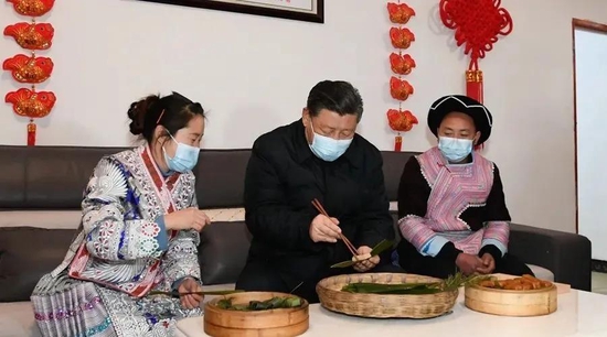 △2021年2月3日，习近平在贵州毕节市黔西县新仁苗族乡化屋村苗族村民赵玉学家，同赵玉学一家边聊家常边制作当地传统节日食品黄粑。