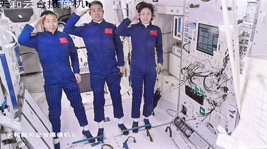 2022年6月5日在北京航天飞行控制中心拍摄的进驻天和核心舱的航天员陈冬（中）、刘洋（右）、蔡旭哲向全国人民敬礼的画面。新华社记者 李鑫 摄