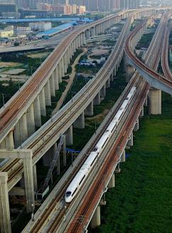 变身开放高地 迈向"中心城市",一列动车组列车驶过郑州市区(2017年8月