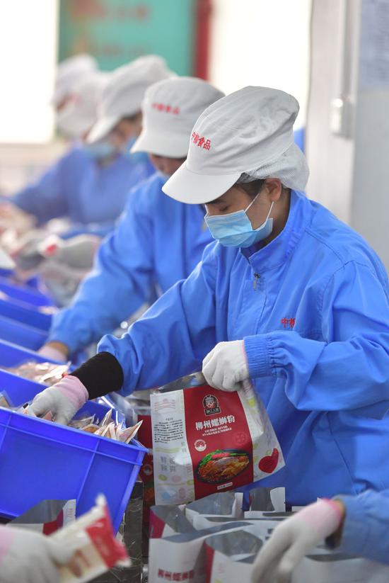 在柳州市螺蛳粉产业园广西中柳食品科技有限公司生产车间，工人在生产线上包装螺蛳粉（2月2日摄）。新华社记者 黄孝邦 摄
