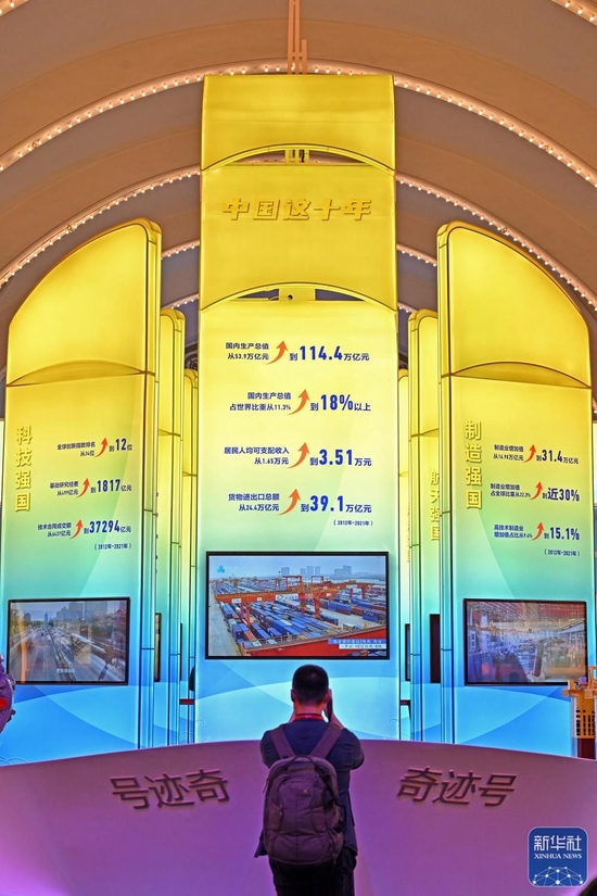 10月8日，一名观众在中央综合展区内拍摄中国经济“奇迹”号巨轮模型。新华社记者 李鑫 摄
