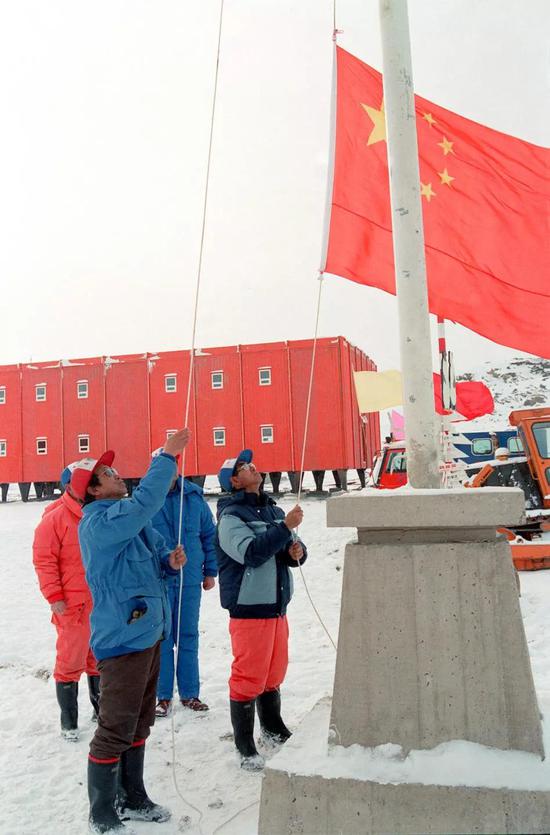 在1989年1月26日中山站举行的奠基仪式上，队员们升起鲜艳的五星红旗。新华社记者张继民摄