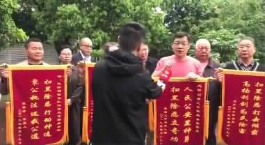 大兵和小区业主代表自制锦旗，准备送给公安部门表示感谢。 　　（视频截图）