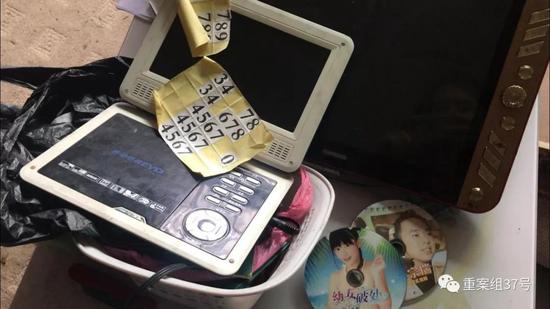 ▲龙和的视频播放器和旁边的淫秽光碟，其中一张上面有“幼女破处字样”。新京报记者 侯雪琪 摄