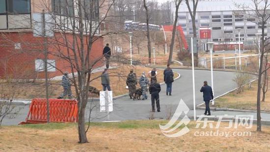 在宿舍楼外巡逻的俄罗斯安全人员和巡逻犬。