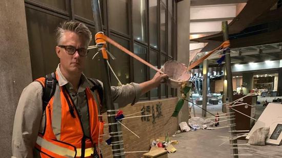  Jim Spellman poses with a makeshift catapult at the campus of Hong Kong Polytechnic University。 /CGTN Photo