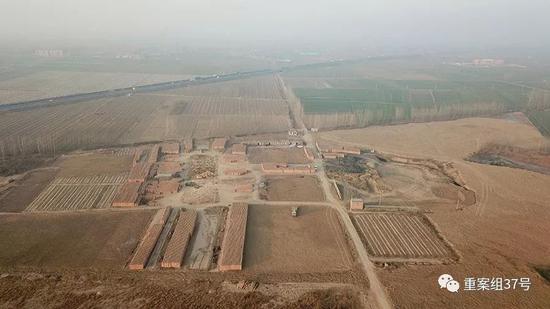  ▲12 月 10 日，航拍郓城县西营窑厂复垦地，道路右侧深坑掩埋着生活垃圾和危废品。新京报记者 王飞 摄