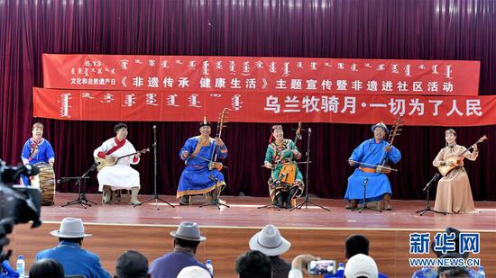 6月10日，内蒙古赤峰市巴林右旗的格斯尔艺术家们进社区表演。新华社发（袁野 摄）