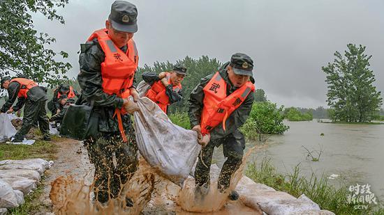 △7月15日，武警安徽省总队合肥市支队官兵冒雨抢险加高加固长江堤坝。