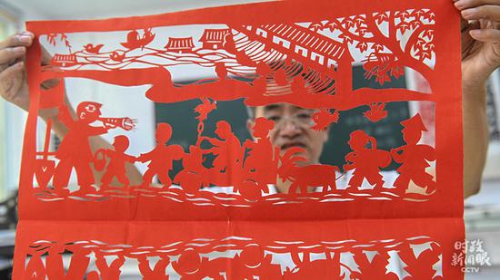 △安徽阜阳市，剪纸艺术家葛庭友展示创作的“安全转移群众”作品。