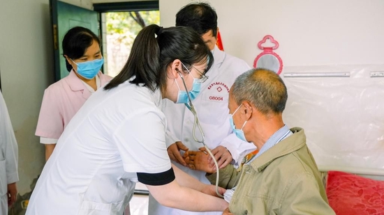 图为蒋朝辉为患者何大爷听诊.周晓瓯 摄