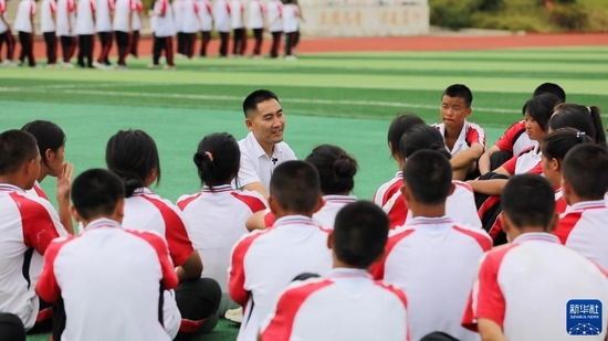 贵州省望谟县实验高中党总支副书记、副校长刘秀祥在新生军训间隙，和学生们聊天（2022年8月26日摄）。新华社记者 周宣妮 摄
