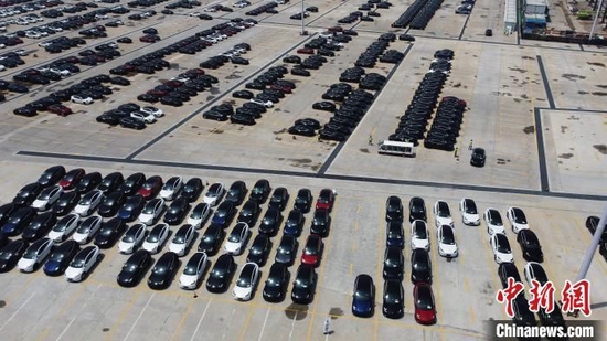 资料图：刚下生产线的国产特斯拉正一辆辆有序停在工厂内。　殷立勤 摄