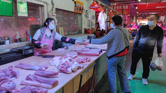 消费者在四川省三台县的农贸市场买猪肉。新华社记者袁波 摄