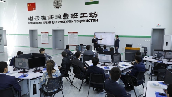 在塔吉克斯坦首都杜尚别的鲁班工坊内，来自中国的老师向学生讲解测绘实践知识。