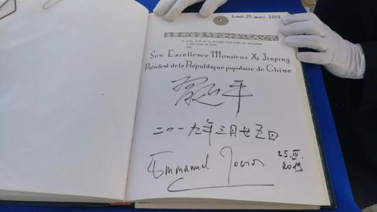 △习近平和马克龙在贵宾簿上签字。(央视记者李铮拍摄)