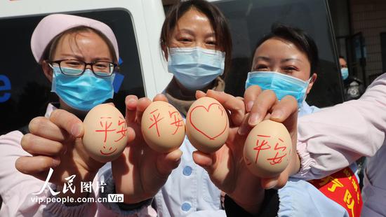 2020年2月4日，云南省昆明市，出征队员手中写着“平安”的鸡蛋，包含了“平平安安”和“平安回来”的祝福。杨峥/人民图片