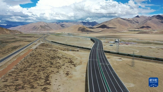 在京藏高速那曲至羊八井段，火车经过跨青藏铁路特大桥（5月30日摄，无人机照片）。新华社发（胡雪峰 摄）