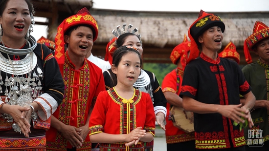  △身着民族服饰的当地村民在毛纳村广场上唱起民歌。（总台央广记者潘毅拍摄）