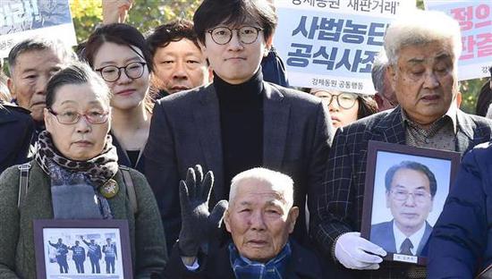 在法院门前合影的韩国受害劳工及家属。（共同社）