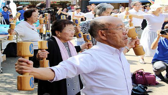 2018年9月17日,日本东京,日本老年人举木制哑铃锻炼身体,庆祝"敬老节"