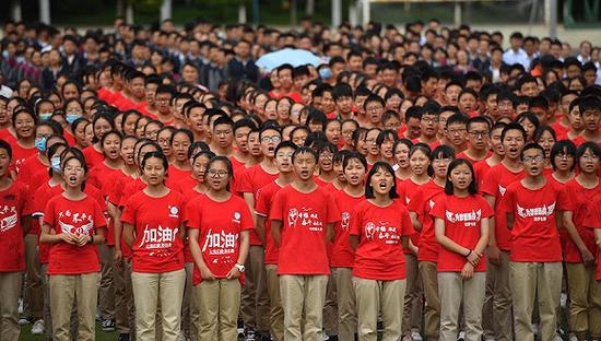  2020年6月29日，昆明一中学，初三年级学生高喊口号为高三学长学姐加油。来源：视觉中国