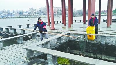 黄敏莉在寒风中清理湖面垃圾。长江日报记者史强 摄