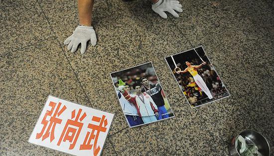 张尚武卖艺时摆放的照片和姓名。(图片来源:视觉中国)