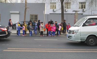 12月3日，北京，大风天气，放学后家长在寒风中接孩子们放学。 图/视觉中国