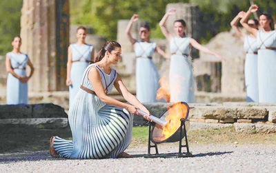 10月18日，北京冬奥会火种在希腊古奥林匹亚采集成功。图为扮演最高女祭司的演员点燃火种。新华社记者 郑焕松摄