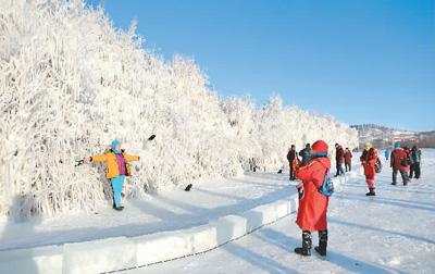 黑龙江省大兴安岭地区加格达奇区，游客在冰挂前拍摄。魏建顺摄（人民图片）