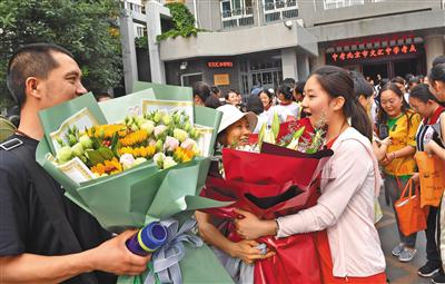 昨日下午4点，2019年北京中考最后一科地理考试结束。北京文汇中学考点，一名考生收到了父母送来的鲜花。
新京报记者 李木易 摄