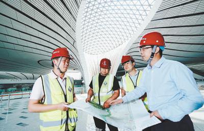 吴志晖（右一）正带领工人对航站楼工程进行局部完善和调整检测工作。