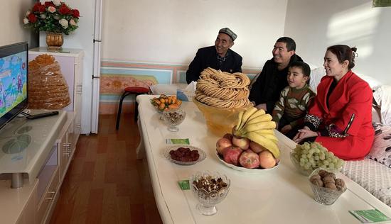 阿卜都克尤木·肉孜一家三代人正在新装修的客厅看电视。阿尔达克摄