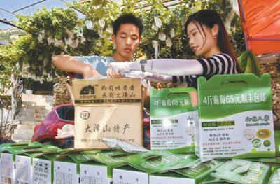 山东平度市大泽山镇尹家村村民正在包装通过电商渠道销售的鲜食葡萄。人民视觉