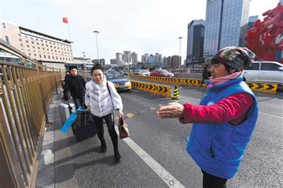 葛玉花在北京西站南广场为旅客做引导。