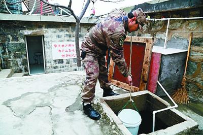 民兵马洪波在取用泥鳅净化的雨水。光明日报记者 蒋新军摄