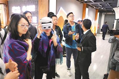 华文媒体代表在丽江的数字古城5G展馆体验景区VR直播。