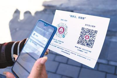 一名住户在扫码"北京健康宝"小程序