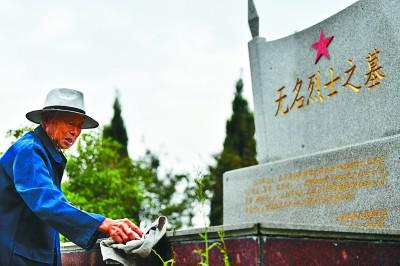 安徽怀远县陈集镇，88岁的胡兆伦老人在烈士陵园擦拭无名烈士墓碑。新华社发