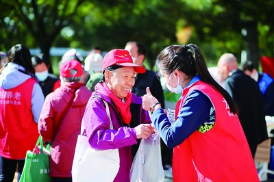良好的社会保障让老年人有了更多获得感和幸福感。图为北京市朝阳区建外街道建国里社区，在“以邻为伴，幸福为老”邻里节、重阳节文化活动中，一位老年人开心地与志愿者交流。任晓宇摄/光明图片