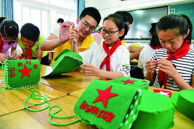 江苏大学志愿者指导小学生制作“红军包”。石玉成摄/光明图片